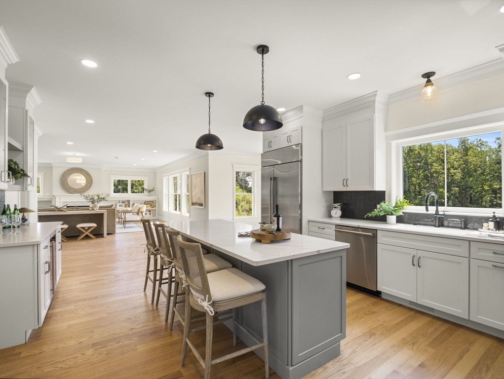 Lot 7 Weeping Willow Drive Andover, MA 01810 - Photo 10 of 42 a kitchen with stainless steel appliances kitchen island granite countertop a stove a sink a dining table and chairs with wooden floor