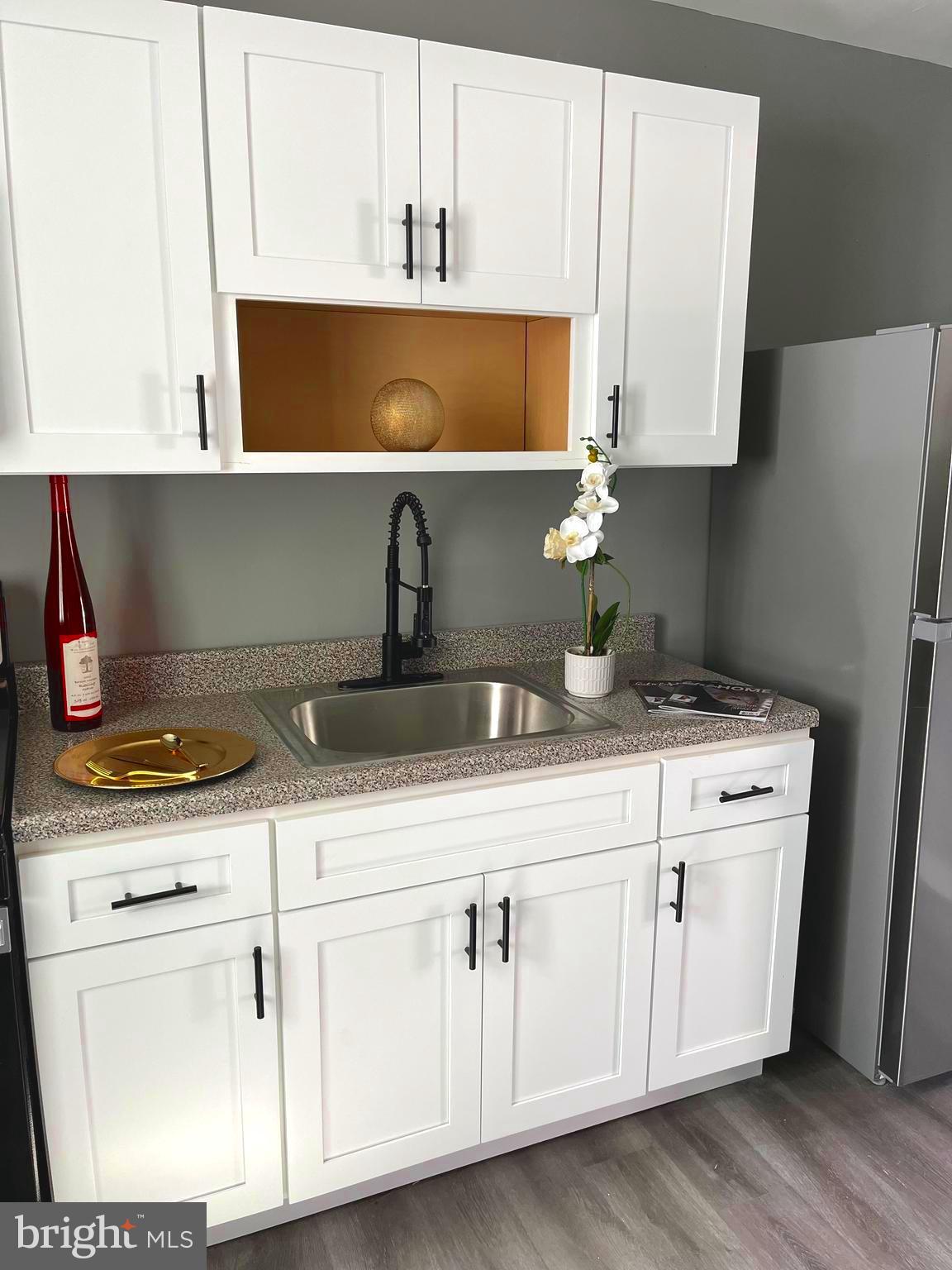 a kitchen with white cabinets appliances and sink