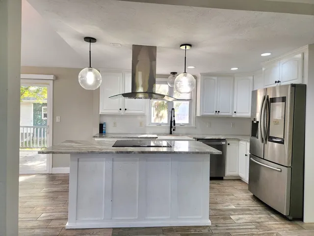 a kitchen with stainless steel appliances granite countertop a sink a stove and a refrigerator