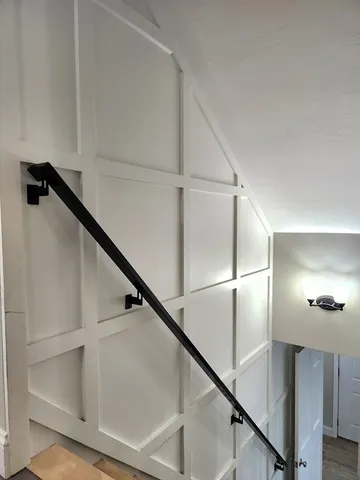 a view of staircase with white walls and railing