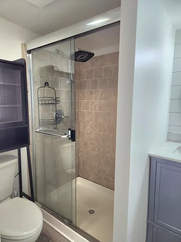 a bathroom with a shower a toilet and a sink