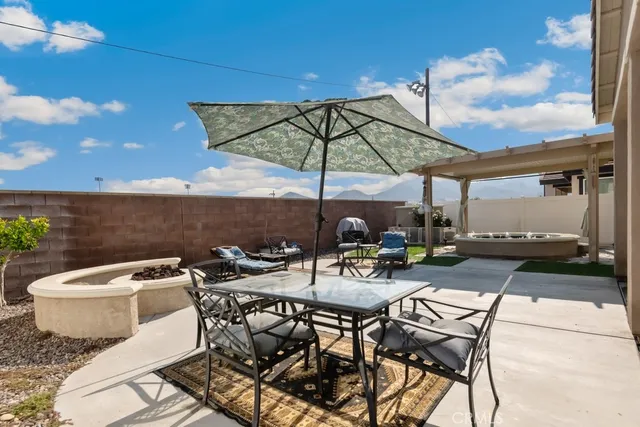 a view of a patio with table and chairs under an umbrella