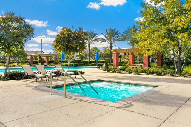 a view of patio with chairs and table under an umbrella with large trees