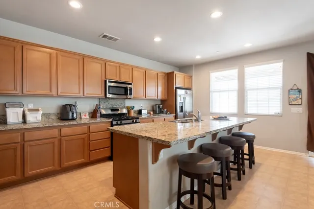 a kitchen with cabinets a sink and chairs