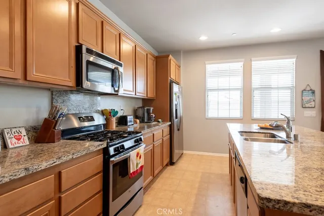 a kitchen with stainless steel appliances granite countertop a stove a sink and a microwave