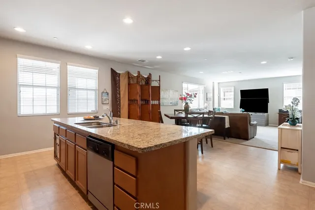 a large kitchen with sink a refrigerator and chairs