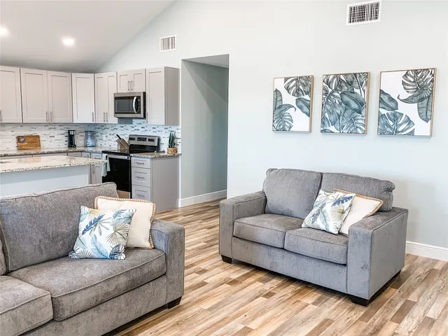 a living room with furniture and kitchen view