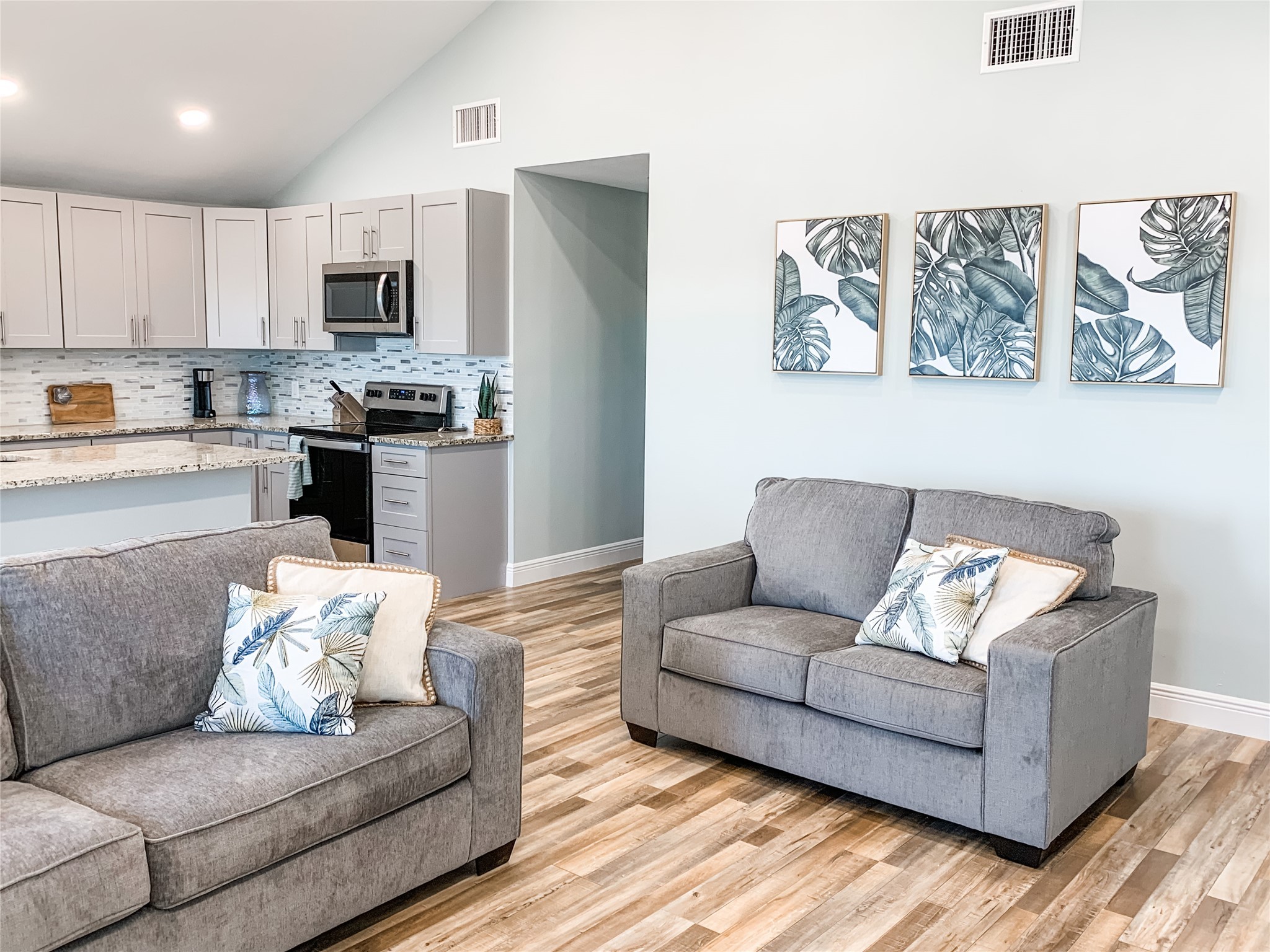 a living room with furniture and kitchen view