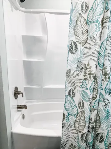 a bathroom with a bathtub and shower