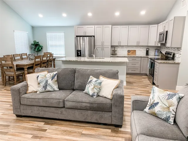 a living room with furniture and kitchen view