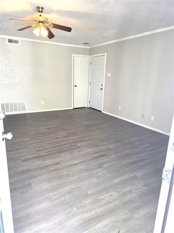 a view of an empty room with wooden floor