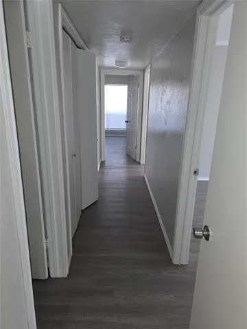 a view of a hallway with wooden floor
