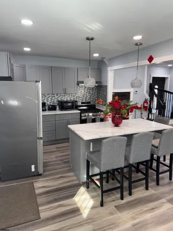 a kitchen with a dining table chairs cabinets and stainless steel appliances