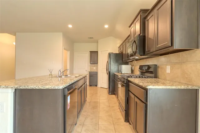 a kitchen with stainless steel appliances granite countertop a sink and a stove