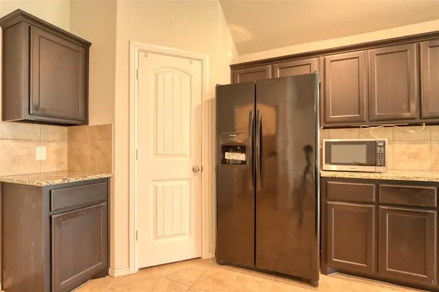 a kitchen with granite countertop a refrigerator and a sink