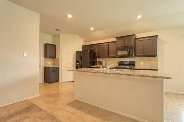 a kitchen with stainless steel appliances a refrigerator sink stove microwave and cabinets