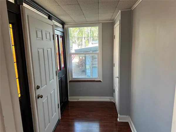a view of hallway with windows and wooden floor