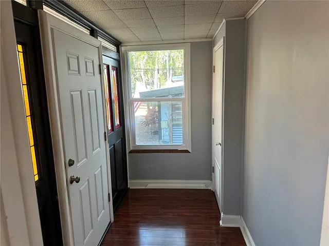 a view of hallway with windows and wooden floor