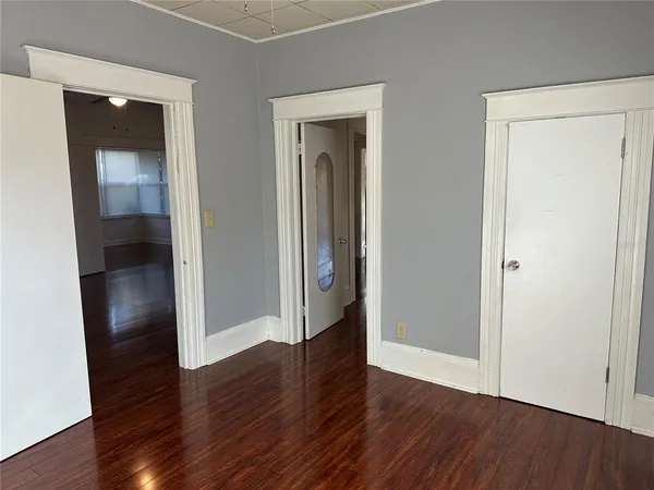 an empty room with wooden floor and closet