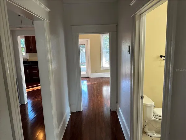 a view of a hallway with wooden floor and stairs