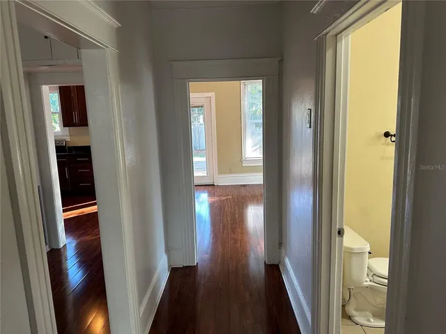 a view of a hallway with wooden floor and stairs