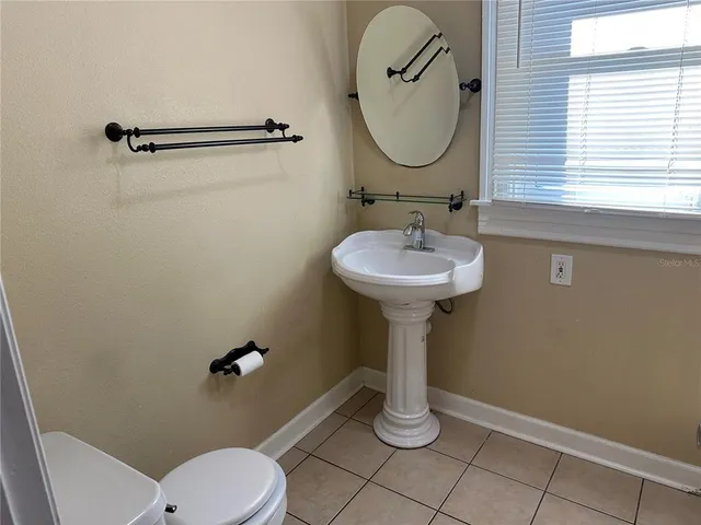 a bathroom with a sink a mirror a toilet and window