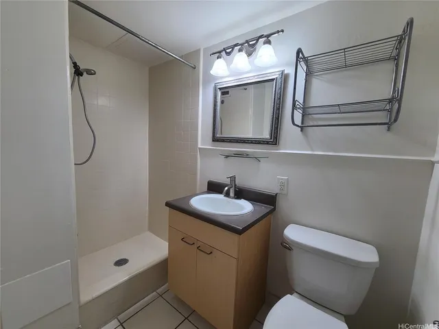 a bathroom with a toilet sink vanity tub and mirror