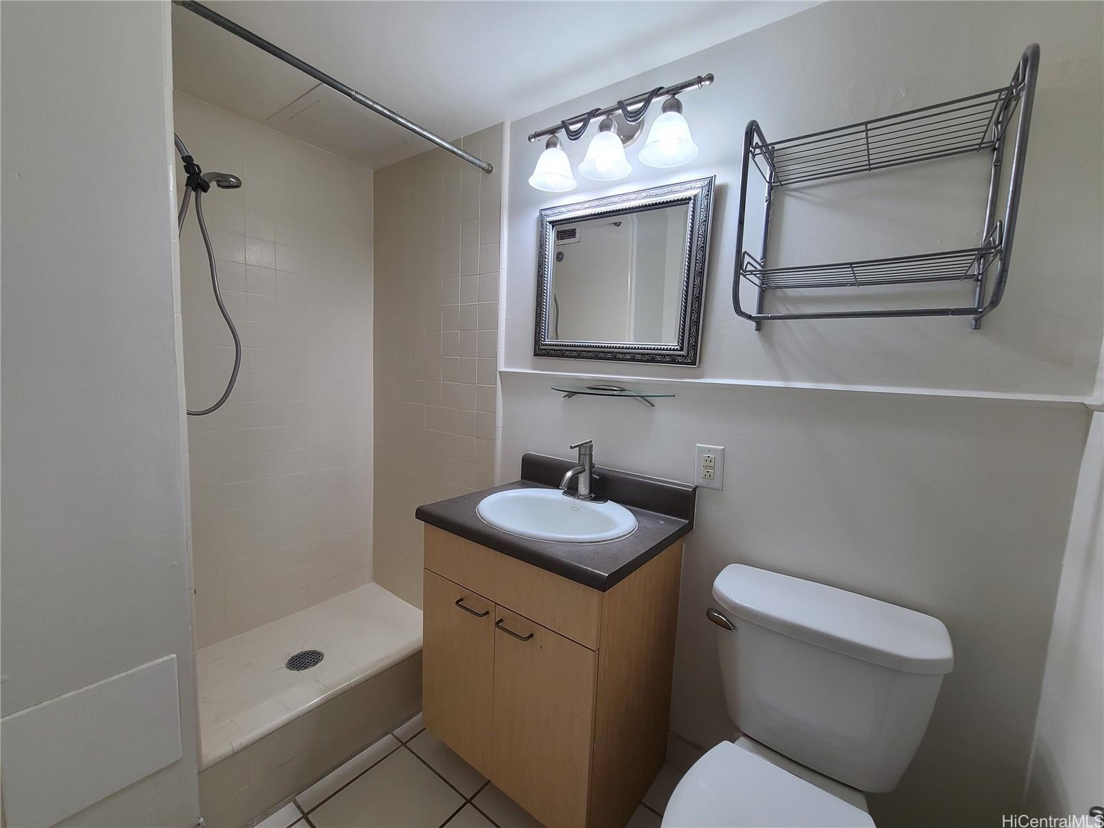 2442 Tusitala Street, Unit 210 Honolulu, HI 96815 - Photo 3 of 5 a bathroom with a toilet sink vanity tub and mirror