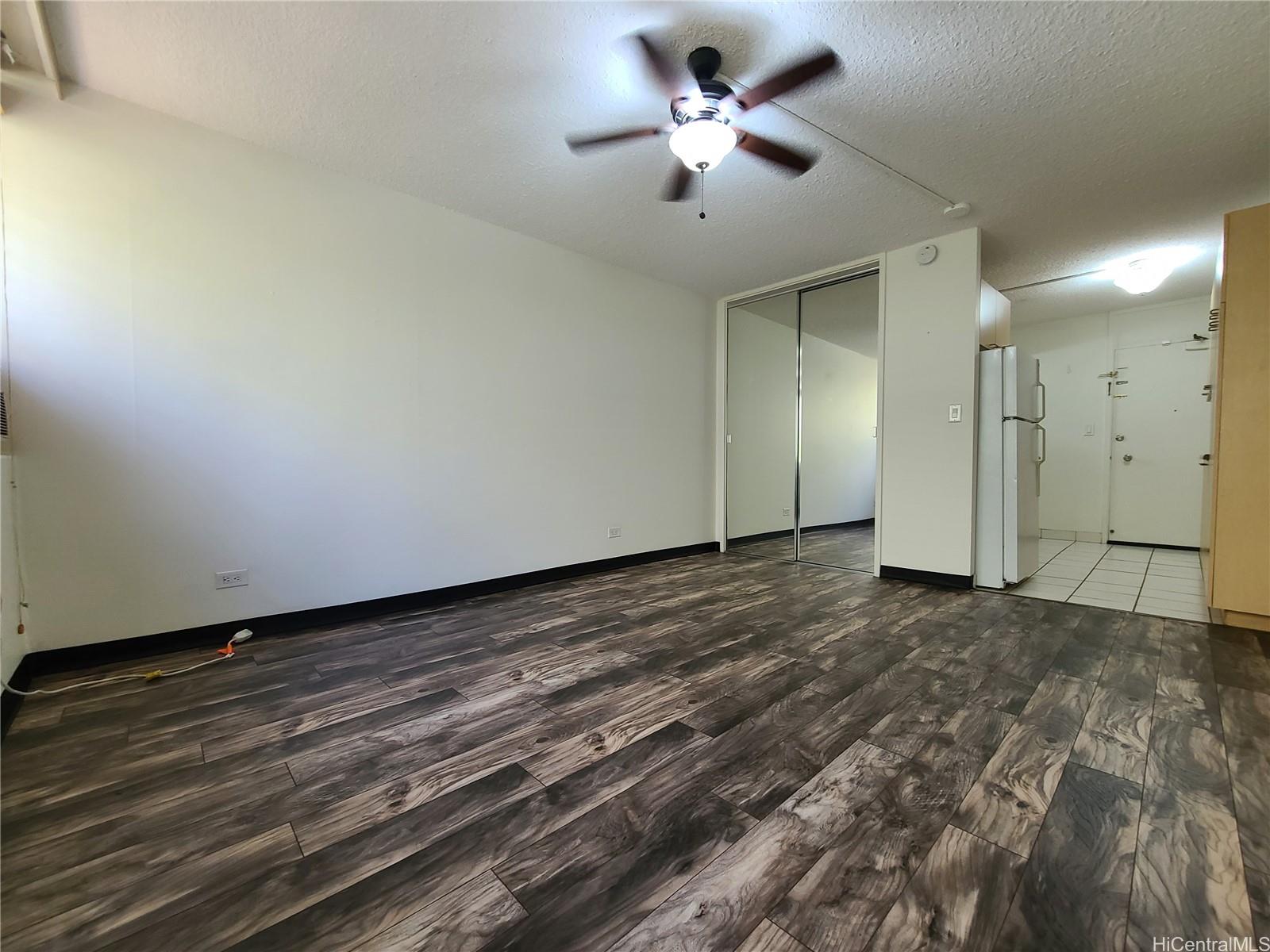 2442 Tusitala Street, Unit 210 Honolulu, HI 96815 - Photo 4 of 5 a view of a big room with wooden floor and a ceiling fan