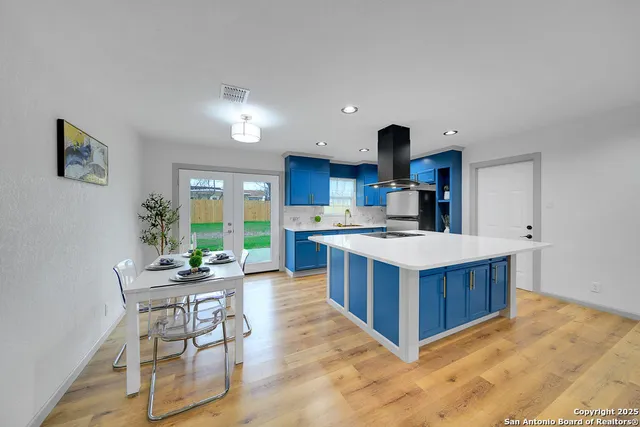 a kitchen with kitchen island granite countertop a sink and a stove