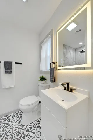 a bathroom with a sink a toilet and mirror