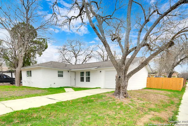 a white house that has a tree in front of it