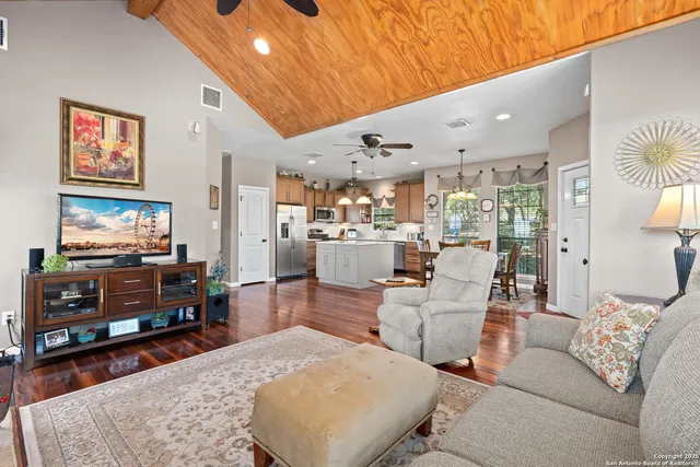 a kitchen with stainless steel appliances kitchen island granite countertop a table chairs and a chandelier