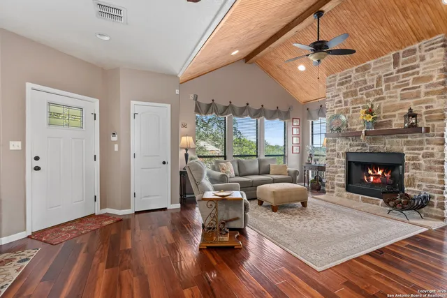a living room with furniture a flat screen tv and a fireplace
