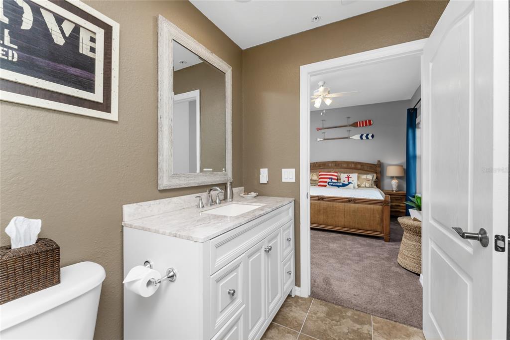 8013 Bay Point Drive Englewood, FL 34224 - Photo 40 of 82 a en suite bathroom with a granite countertop sink and a mirror