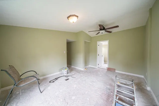 a view of a livingroom with a chandelier fan and a ceiling fan