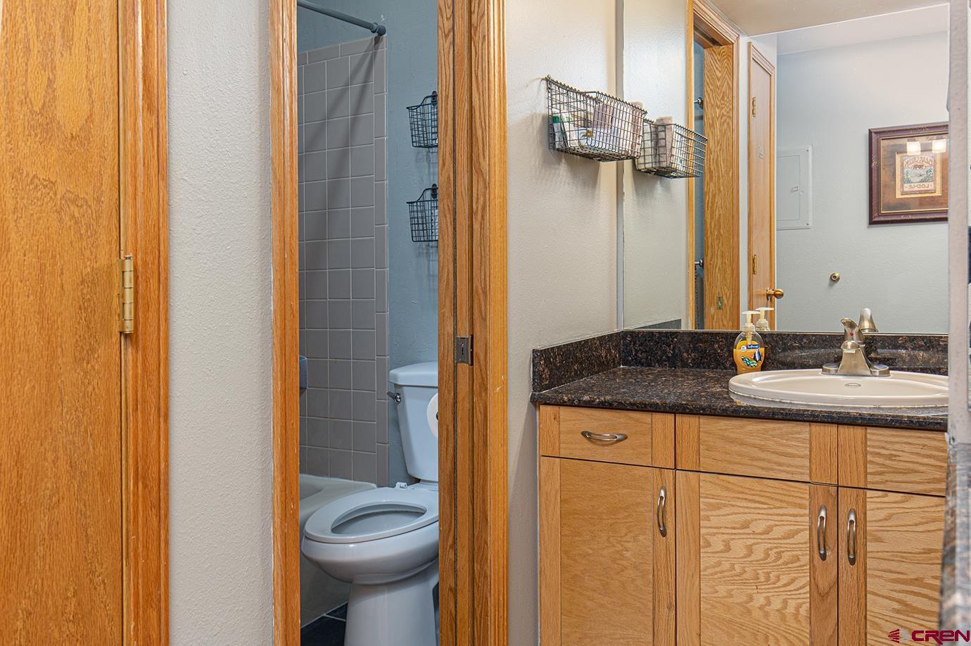 71 Needles Way, Unit 343 Durango, CO 81301 - Photo 9 of 18 a bathroom with a granite countertop sink and a mirror