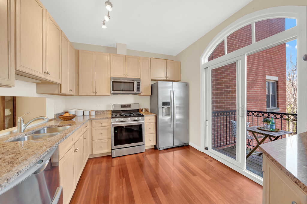 324 East 17th Street Chicago, IL 60616 - Photo 11 of 25 a kitchen with granite countertop a refrigerator oven a sink dishwasher and wooden cabinets with wooden floor