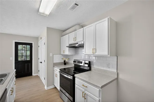 a kitchen with stainless steel appliances granite countertop a stove a sink and a refrigerator