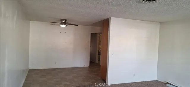 a view of an empty room with a ceiling fan
