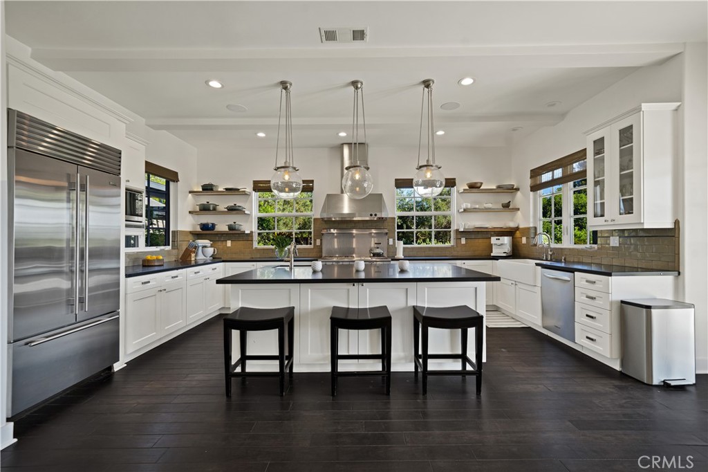 28850 Hampton Place Malibu, CA 90265 - Photo 11 of 53 a kitchen with stainless steel appliances granite countertop a kitchen island a stove a sink a refrigerator and white cabinets