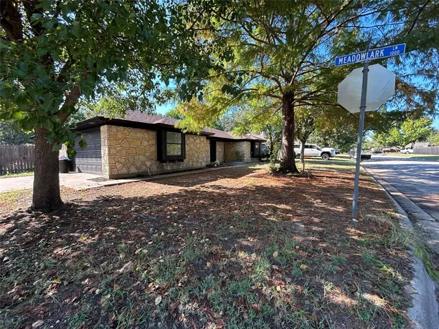 a view of a house with backyard and a tree