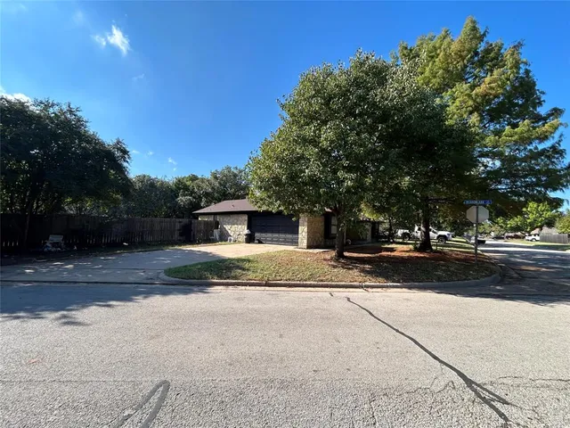 a view of a house with a yard and large tree