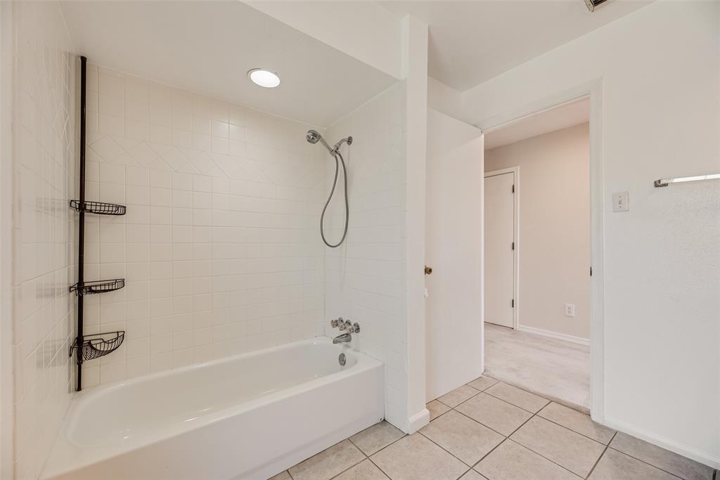4988 Thunder Road Dallas, TX 75244 - Photo 19 of 32 Bathroom featuring a white bathtub, ceramic tile surround, recessed lighting, and tile flooring