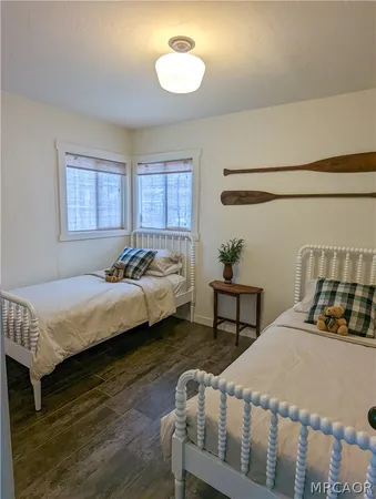 a bedroom with a bed a dresser and potted plant