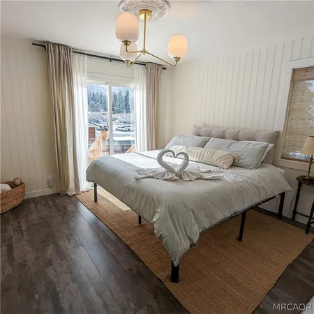 a bedroom with a bed lamp and a large window