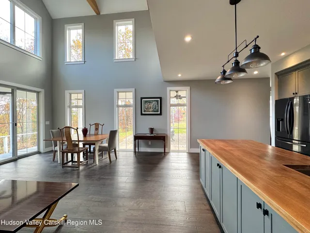 a view of a dining room and livingroom with furniture wooden floor a chandelier