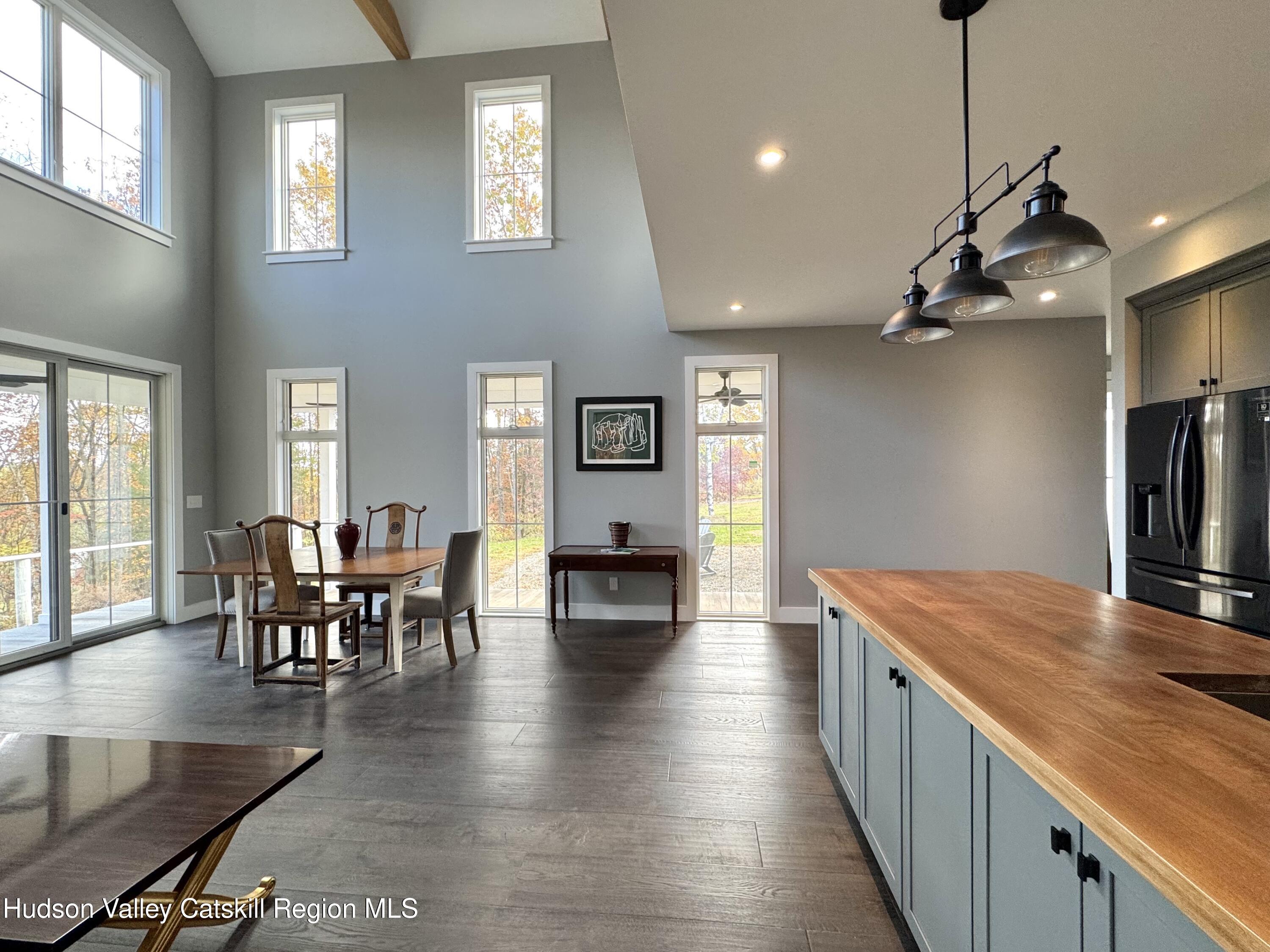 720 Sunny Hill Road Greenville, NY 12083 - Photo 12 of 44 a view of a dining room and livingroom with furniture wooden floor a chandelier