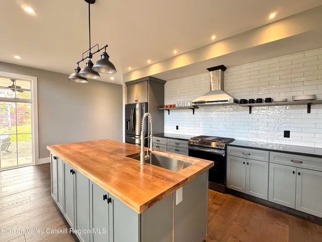 a kitchen with stainless steel appliances granite countertop a sink a stove and a refrigerator