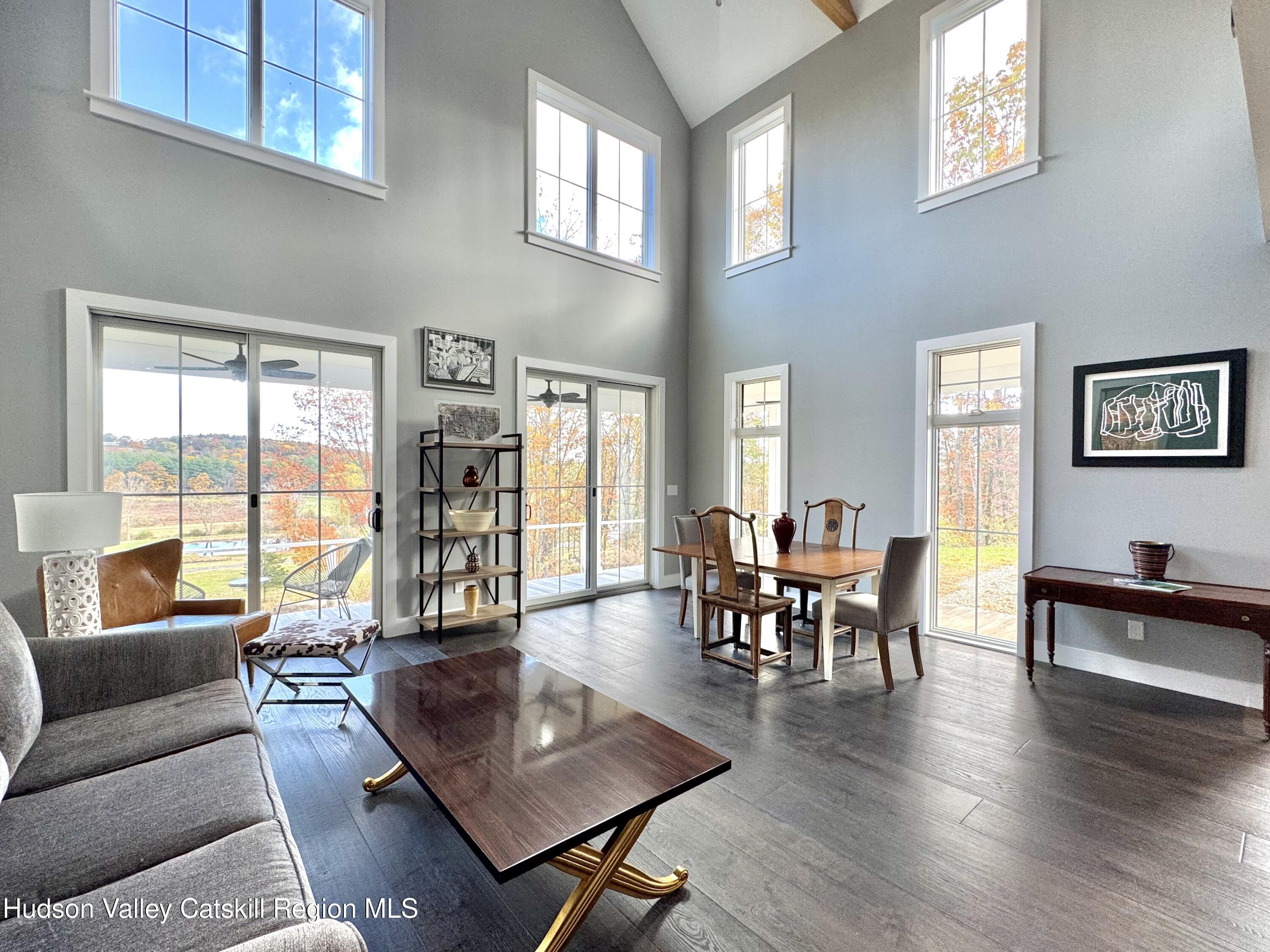 720 Sunny Hill Road Greenville, NY 12083 - Photo 9 of 42 a living room with furniture wooden floor and a floor to ceiling window